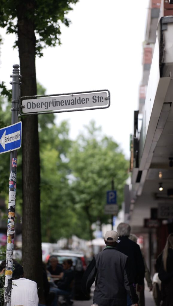 Stra&szlig;enschild Obergr&uuml;newalder Stra&szlig;e mit Passanten im Luisenviertel Wuppertal